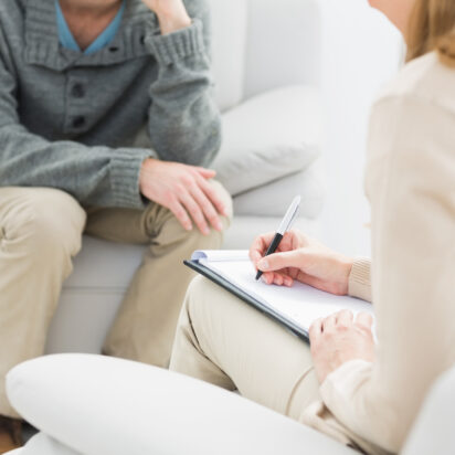 Mid section of man in meeting with a financial adviser at home